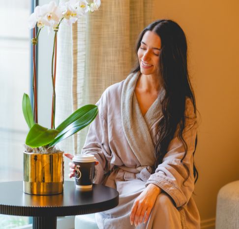 a woman relaxing in a tranquil lounge with a warm beverage