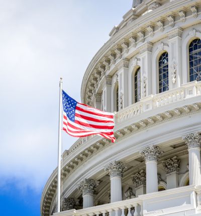 American flag flying in front of the U.S. Capitol dome in Washington, D.C.