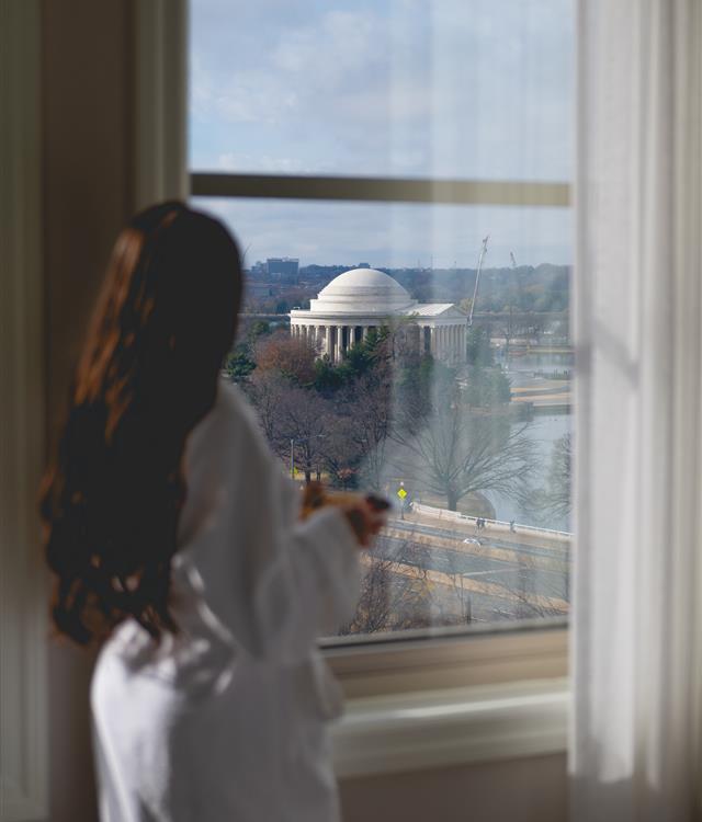 Women's looking out window with a view of the Jefferson Memorial in a suite