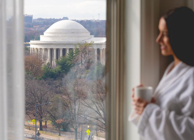 Woman looking out the window of a suite room at Salamander DC