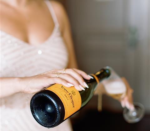 Woman pouring Veuve Clicquot Brut champagne into a glass