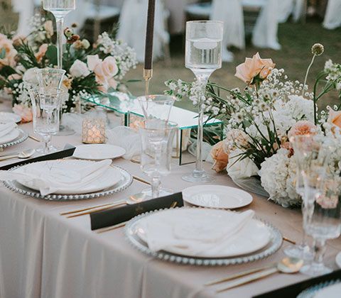 Table with formal place settings, floating candles, and fresh floral arrangements